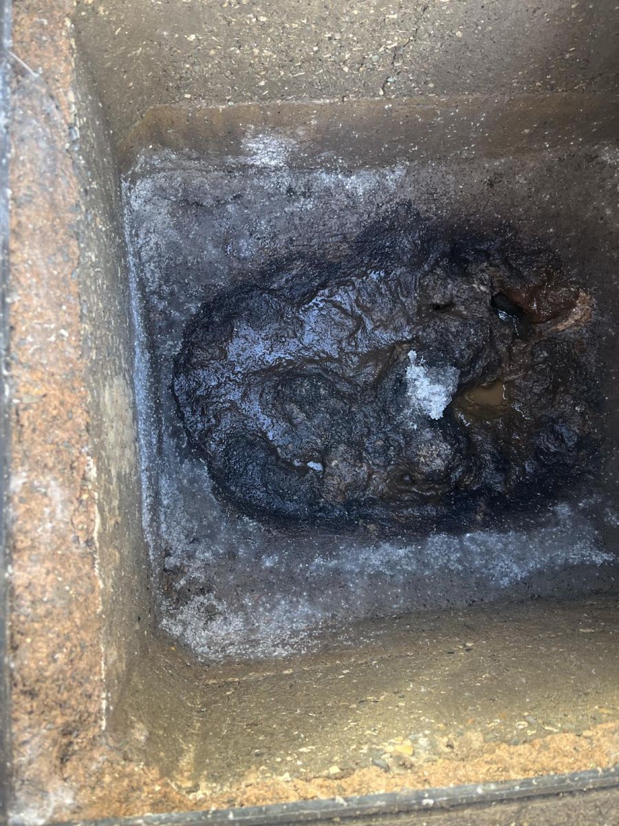 Inspection chamber before cleaning, filled with built-up black waste